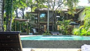 a swimming pool in front of a house at Soleluna Casa Pousada in Trancoso