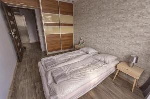 Cama en habitación con pared de ladrillo en Apartament dwupokojowy Poznań- blisko centrum, en Poznan