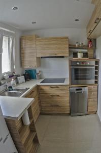 una cocina con armarios de madera y un aparato de acero inoxidable en Apartament dwupokojowy Poznań- blisko centrum, en Poznan