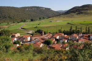 ein kleines Dorf auf einem grünen Feld mit Häusern in der Unterkunft Casa rural LA LAGUNA in Laguna del Marquesado