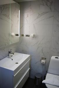 Baño blanco con lavabo y espejo en Håveruds hotell och konferens en Håverud