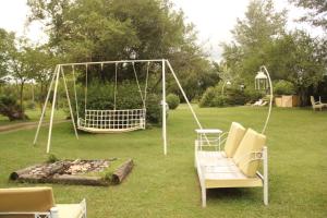 a swing set in a yard with a fire pit at El Cimarron Casa de Campo in La Granja