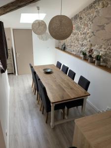 a dining room with a wooden table and chairs at L'Atypique in Sète