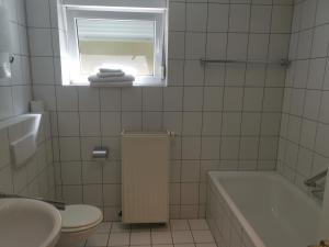 a bathroom with a tub and a toilet and a window at Ferienwohnung Bella in Koblenz +15 photos