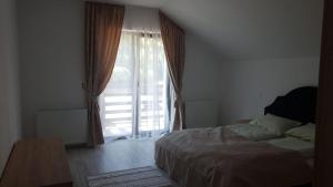 a bedroom with a bed and a large window at Casa Davideea in Colibiţa