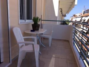 un tavolo e sedie su un balcone con una pianta in vaso di Comfort Apartment in Preveza a Preveza