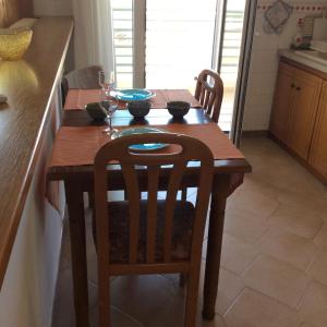 - une table en bois avec 2 chaises et des verres à vin dans l'établissement Comfort Apartment in Preveza, à Prévéza