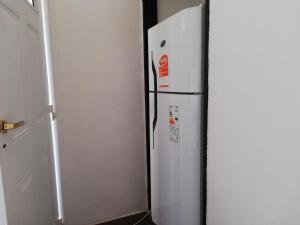 a white refrigerator sitting next to a wall at Don Carlos Apart in San Miguel de Tucumán