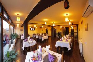 a dining room with white tables and chairs at Pensiunea Oficial in Prejmer