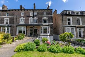 ハロゲートにあるSwan View Apartment, Central Harrogate - 1 bedroom Sleeps 3の花の前に建つ古いレンガ造り