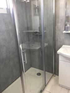 a shower with a glass door in a bathroom at maison proche du Mont Saint Michel in Pontorson +6 photos