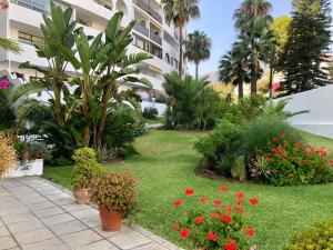 een tuin met bloemen en planten voor een gebouw bij Studio Orquídea Beach 4 in Fuengirola