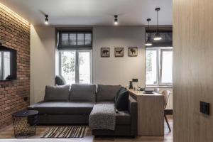 S7 Apartment في ريغا: غرفة معيشة مع أريكة وجدار من الطوب