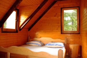1 cama en una cabaña de madera con 2 ventanas en Triangle Woodhouse, en Plav