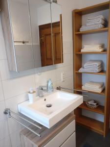a bathroom with a white sink and a mirror at Katharina Ferienwohnung am Eifelsteig in Neroth
