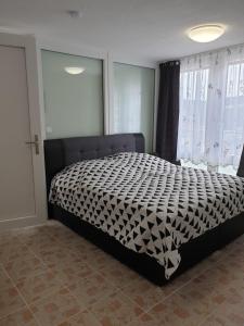 a bedroom with a bed with a black and white comforter at QM Apartment in Triberg