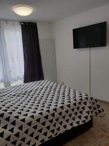 a black and white bed in a room with a television at QM Apartment in Triberg