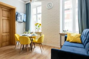 un soggiorno con divano blu, tavolo e sedie di Apartament Francuski a Breslavia