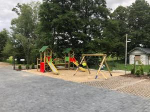 un parque con parque infantil con columpios en Pensjonat WiR na Kaszubach, en Chmielno
