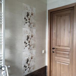a bathroom with a wall with a flower design on it at Apartamenti Danna in Lēdmane