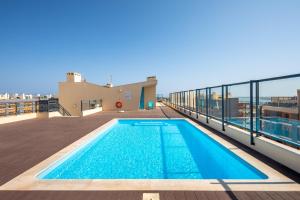 a swimming pool on the roof of a building at OCEANFRONT: Luxury Magnificent Views and Pool in Olhão