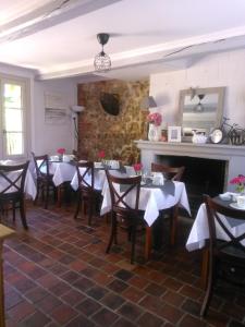 comedor con mesas y sillas y chimenea en Les chambres d'hôtes Le Val d'Honfleur, en Équemauville