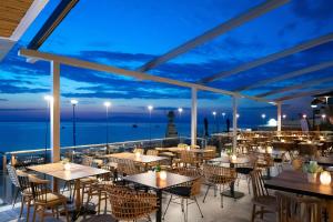 a restaurant with a view of the ocean at night at Sea Level Hotel by Diomedes Group in Polykhrono