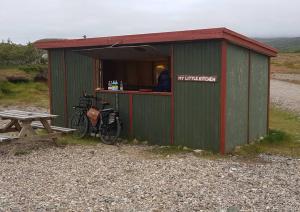 a green building with a table and a bike in it at Stafafell Ready Tents in Stafafell +9 photos