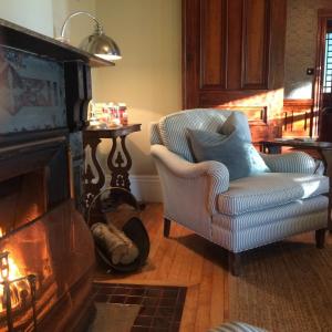 a living room with a chair and a fireplace at The Library Inn in Souris