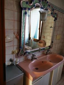 a bathroom with a pink sink and a mirror at Cà ARIVANLIAL Venice villa apartament in Venice-Lido