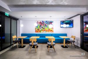 a dining room with tables and a blue bench at Senso Suites in Nea Peramos