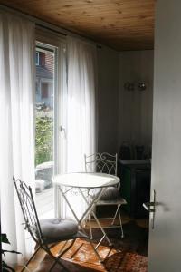 a room with a table and a chair and a window at Gartenzimmer in Rubigen