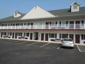 a building with a car parked in a parking lot at Scottish Inns Ronks in Ronks