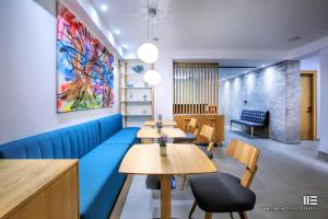 a restaurant with tables and a blue couch at Senso Suites in Nea Peramos