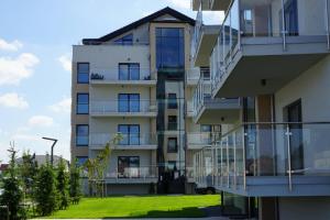 an apartment building with balconies and a lawn at Apartament TOP Pięć Mórz basen&SPA in Sianozety