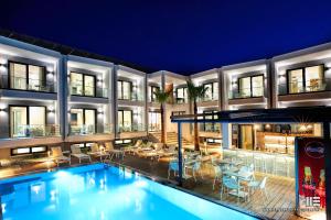 a swimming pool in front of a building at night at Senso Suites in Nea Peramos