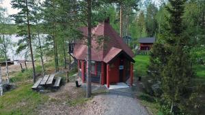 a small red cabin in the middle of a forest at Pistoretki Toivakka in Toivakka