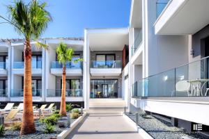 an exterior view of a building with palm trees at Senso Suites in Nea Peramos