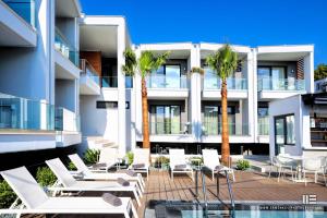 an image of a building with chairs and palm trees at Senso Suites in Nea Peramos