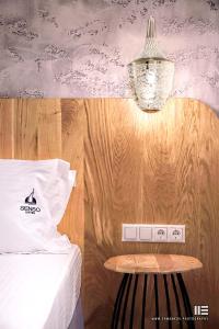 a bedroom with a bed with a table and a lamp at Senso Suites in Nea Peramos
