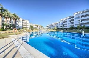 una gran piscina frente a un edificio en Beach Front apartment in Puerto Banus en Marbella