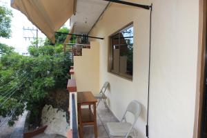 balcón con mesa, sillas y ventana en Zona Romántica Casa Las Magnolias, en Puerto Vallarta