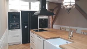 een keuken met een wastafel en een fornuis top oven bij Vanalinna apartement in Viljandi