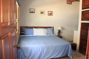 a bedroom with a bed with a blue comforter at Zona Romántica Casa Las Magnolias in Puerto Vallarta