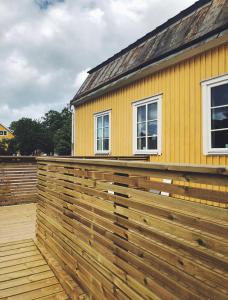 une maison avec une clôture en bois devant elle dans l'établissement Lindens Bed&Breakfast, à Mellerud