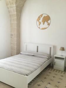 a bedroom with a white bed and a globe on the wall at LA CASETTA 6058 in Conversano