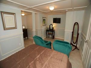 a bedroom with a bed and two chairs and a table at Bellevue Manor in Newport