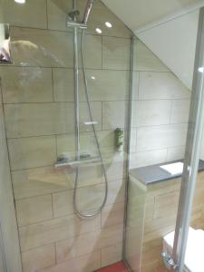 a shower with a hose in a bathroom at Lón Guesthouse in Thorgeirsstadir