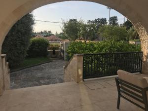 an archway leading to a patio with a bench at White Villa in Selva di Fasano