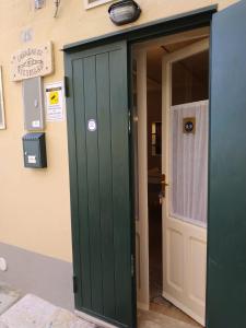 eine grüne Tür in einem Gebäude mit einem Schild an der Wand in der Unterkunft Casa Sassi Vizziello in Matera
